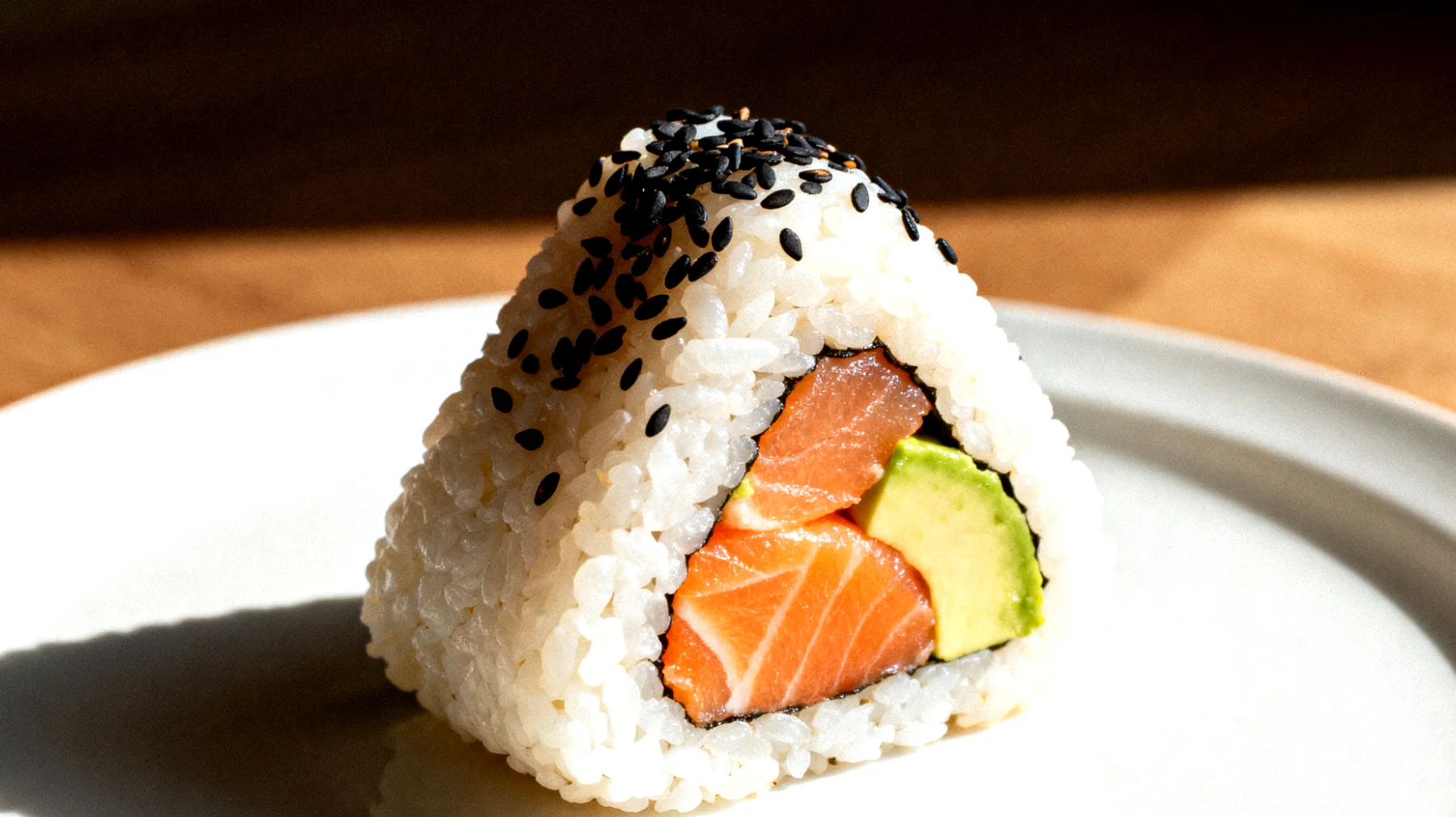 Onigiri con salmone, avocado e semi di sesamo"