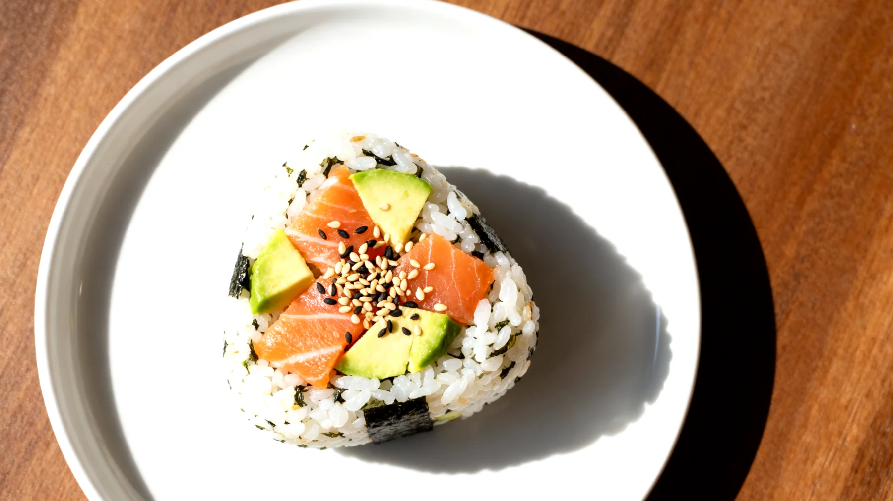 Onigiri con salmone, avocado e semi di sesamo"